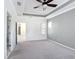 A spacious bedroom features a tray ceiling, a ceiling fan, gray carpet, and a small window at 1513 Resolute St, Celebration, FL 34747