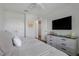 This is a stylish bedroom with a large television, dresser, and light gray walls and trim at 15540 Blackbead St, Winter Garden, FL 34787