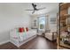 This is a nicely decorated bedroom with dark wood floors, cute artwork, and a comfortable chair at 15540 Blackbead St, Winter Garden, FL 34787