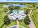 Aerial view of the community clubhouse with a luxury pool, palm trees and meticulously landscaped grounds in a lakeside setting at 15540 Blackbead St, Winter Garden, FL 34787
