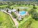 Aerial view of the clubhouse, pool, and surrounding community amenities, set against a backdrop of lush landscaping and a lake at 15540 Blackbead St, Winter Garden, FL 34787