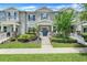 Charming townhome featuring a covered porch, landscaped yard, and a stylish blue front door at 15540 Blackbead St, Winter Garden, FL 34787