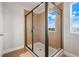 Tiled shower featuring glass enclosure, shower head and natural light at 15540 Blackbead St, Winter Garden, FL 34787