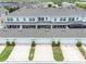 Aerial view showcases attached townhomes with garages, driveways, backyard patios, and neatly manicured landscaping at 15540 Blackbead St, Winter Garden, FL 34787