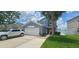 Two-story home featuring a two car garage, palm tree, and manicured front yard at 1827 Meadow Pond Way, Orlando, FL 32824