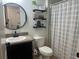 Bright bathroom featuring a stylish sink vanity, decorative shelves, and a clean, well-maintained toilet at 1868 Katz Crossing Dr, Kissimmee, FL 34744