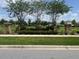 Attractive community entrance showcasing lush landscaping, trees, and stone pillars at 1868 Katz Crossing Dr, Kissimmee, FL 34744