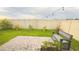 Spacious backyard featuring a well-maintained lawn, a brick patio, a wood bench, and privacy fence at 1875 Spring Shower Cir, Kissimmee, FL 34744