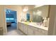 Well-lit bathroom with double vanity, walk-in shower and an open view into the bedroom at 1875 Spring Shower Cir, Kissimmee, FL 34744