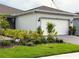 Charming home featuring a well-manicured front yard with colorful landscaping and an attached two-car garage at 1875 Spring Shower Cir, Kissimmee, FL 34744
