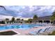Inviting community pool featuring ample seating, palm trees, and pristine blue water for relaxing and socializing at 1875 Spring Shower Cir, Kissimmee, FL 34744