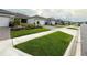 A street view showcasing the well-maintained lawns and similar architectural design of the neighborhood homes at 1875 Spring Shower Cir, Kissimmee, FL 34744