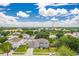 Aerial view of a tan two-story home situated in a neighborhood with lush greenery and blue skies at 1912 Maury Rd, St Cloud, FL 34771