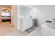 Bright bathroom with dual sinks, white cabinets, and soaking tub at 1912 Maury Rd, St Cloud, FL 34771