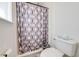 Bathroom with a shower featuring patterned shower curtain, toilet, and window at 1912 Maury Rd, St Cloud, FL 34771