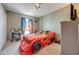 bedroom featuring a race car bed, window with curtains, and decorative shelving at 1912 Maury Rd, St Cloud, FL 34771