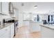 Modern kitchen with white cabinets, stainless steel appliances, and a granite countertop island open to dining area at 1912 Maury Rd, St Cloud, FL 34771