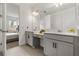Bathroom featuring dual sinks, white cabinets, and updated fixtures at 19267 Allium Pl, Orlando, FL 32827