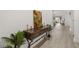 View of the home's hallway featuring hardwood floors, console table, decor, and white walls at 19267 Allium Pl, Orlando, FL 32827