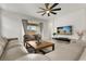 View of the living room featuring a large leather sofa, chairs, and a ceiling fan at 19267 Allium Pl, Orlando, FL 32827
