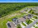 Aerial view of community homes with solar panels, a pool, and green space surrounded by a beautiful wooded landscape at 209 Willow Bend Dr, Davenport, FL 33897