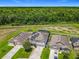 Aerial view of community homes with solar panels, a pool, and green space surrounded by a beautiful wooded landscape at 209 Willow Bend Dr, Davenport, FL 33897