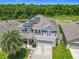 Aerial view of community homes with solar panels and green space surrounded by a beautiful wooded landscape at 209 Willow Bend Dr, Davenport, FL 33897