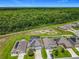 Aerial view of community homes with solar panels, a pool, and green space surrounded by a beautiful wooded landscape at 209 Willow Bend Dr, Davenport, FL 33897
