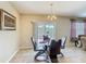 Bright dining area features a glass table, modern chandelier, and sliding door to the lanai at 209 Willow Bend Dr, Davenport, FL 33897