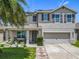 Charming two-story home with well-maintained landscaping, a palm tree, a covered porch and a two car garage at 209 Willow Bend Dr, Davenport, FL 33897
