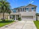 Charming two-story home with well-maintained landscaping, a palm tree, a covered porch and a two car garage at 209 Willow Bend Dr, Davenport, FL 33897