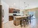 Gourmet kitchen with granite counters, dark wood cabinets, stainless appliances, and island seating at 209 Willow Bend Dr, Davenport, FL 33897