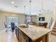 Modern kitchen island with granite countertops, pendant lighting, and view of the living area at 209 Willow Bend Dr, Davenport, FL 33897