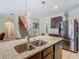 Gourmet kitchen featuring island, granite counters, stainless steel appliances, and stairs to second floor at 209 Willow Bend Dr, Davenport, FL 33897
