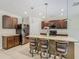 Kitchen featuring a granite island with pendant lighting, stainless appliances and three barstools at 209 Willow Bend Dr, Davenport, FL 33897