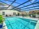 Screened pool with a tiki bar and chairs, and clear blue water at 209 Willow Bend Dr, Davenport, FL 33897