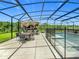 Screened pool area features an outdoor kitchen with a bar, an outdoor dining set, and clear views of the backyard at 209 Willow Bend Dr, Davenport, FL 33897