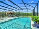 Backyard oasis features a pool, spa, outdoor kitchen, and plenty of deck space in a screened enclosure at 209 Willow Bend Dr, Davenport, FL 33897