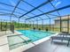 Sparkling pool with attached spa, sun loungers, and screened enclosure offers the perfect outdoor oasis at 209 Willow Bend Dr, Davenport, FL 33897