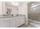 Bathroom featuring double vanity with white cabinets, granite counters, and a walk-in shower with glass door at 2161 Lelani Cir, Davenport, FL 33897