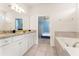 Bright bathroom with a granite countertop vanity and a soaking tub, creating a luxurious experience at 2161 Lelani Cir, Davenport, FL 33897