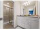 Bathroom featuring granite countertops, a double sink vanity, and a tiled shower at 2161 Lelani Cir, Davenport, FL 33897