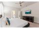 Bright bedroom with a ceiling fan, featuring a TV and stylish furniture, enhancing comfort and entertainment at 2161 Lelani Cir, Davenport, FL 33897