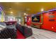 The vibrant entertainment room is designed with unique decor, a large screen, and comfortable seating at 2161 Lelani Cir, Davenport, FL 33897