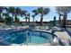 Inviting community hot tub with comfortable lounge chairs and lush tropical landscaping, perfect for relaxation and socializing at 2161 Lelani Cir, Davenport, FL 33897