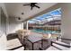 Covered outdoor patio with comfortable seating, a dining table, and a view of the pool and landscaped backyard at 2161 Lelani Cir, Davenport, FL 33897