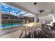 Covered patio featuring a dining area, lounge seating, and views of the private pool and screened enclosure at 2161 Lelani Cir, Davenport, FL 33897