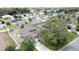 A high aerial neighborhood shot of a blue home with a long driveway surrounded by trees and green lawns at 238 Sunridge Woods Blvd, Davenport, FL 33837