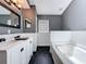 Bathroom featuring a soaking tub, modern vanity, and gray walls, complemented by black hexagonal tile flooring at 238 Sunridge Woods Blvd, Davenport, FL 33837