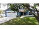 Exterior showcasing a blue single-story home with well-manicured lawn and a two-car garage at 238 Sunridge Woods Blvd, Davenport, FL 33837
